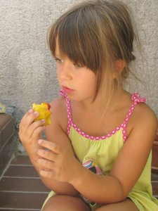 Menina que come o pêssego